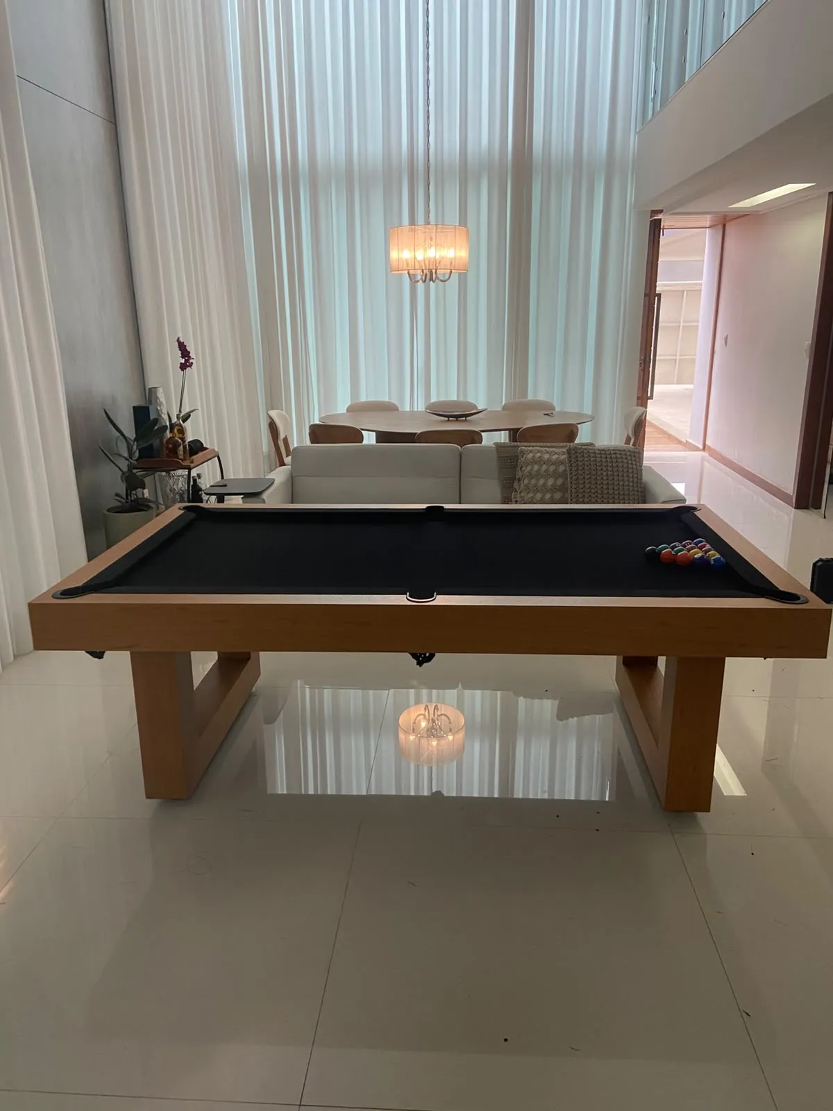 Mesa de bilhar em madeira natural instalada em uma sala contemporânea