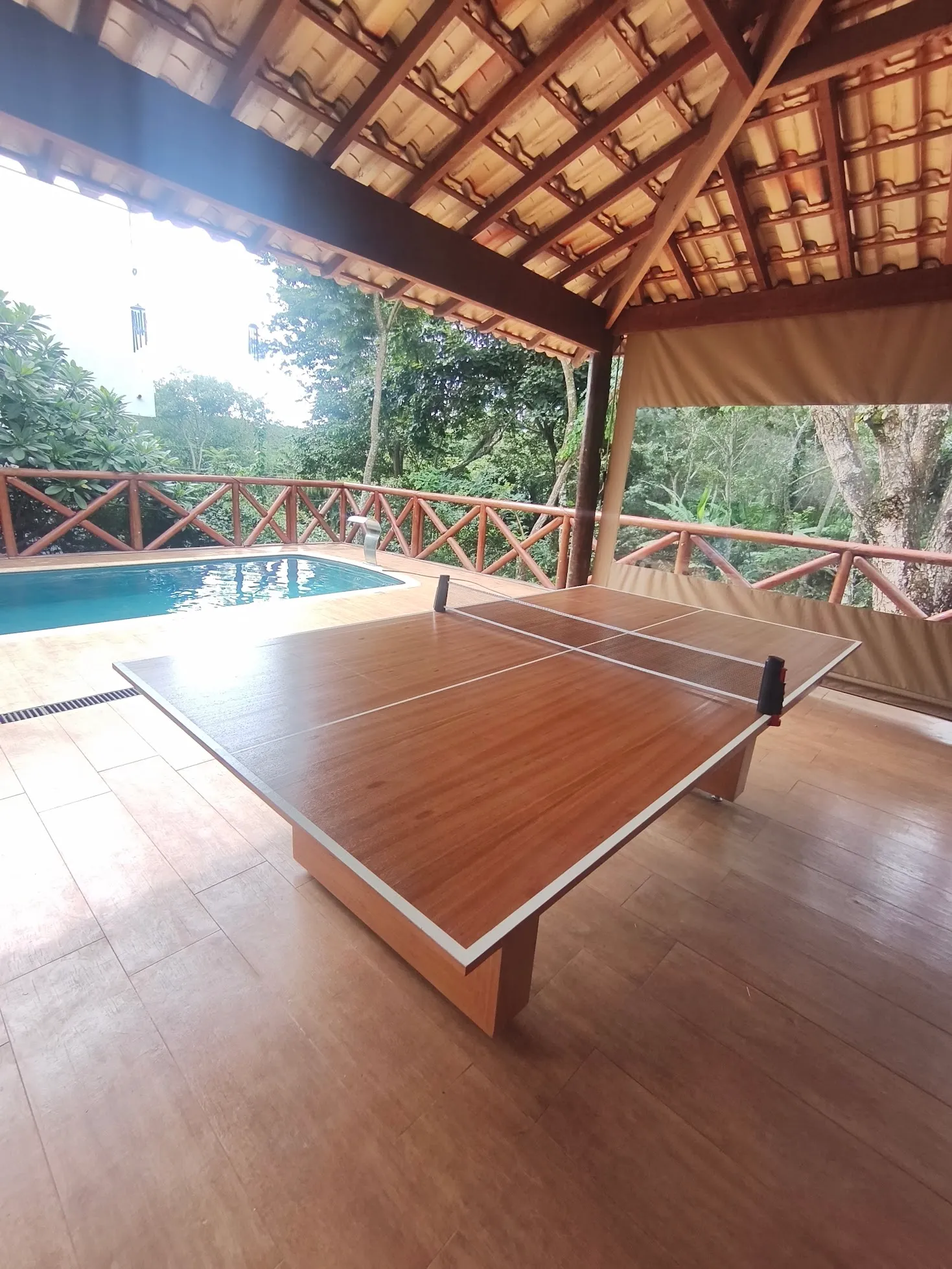 Mesa 3 em 1 configurada para ping-pong ao lado de uma piscina